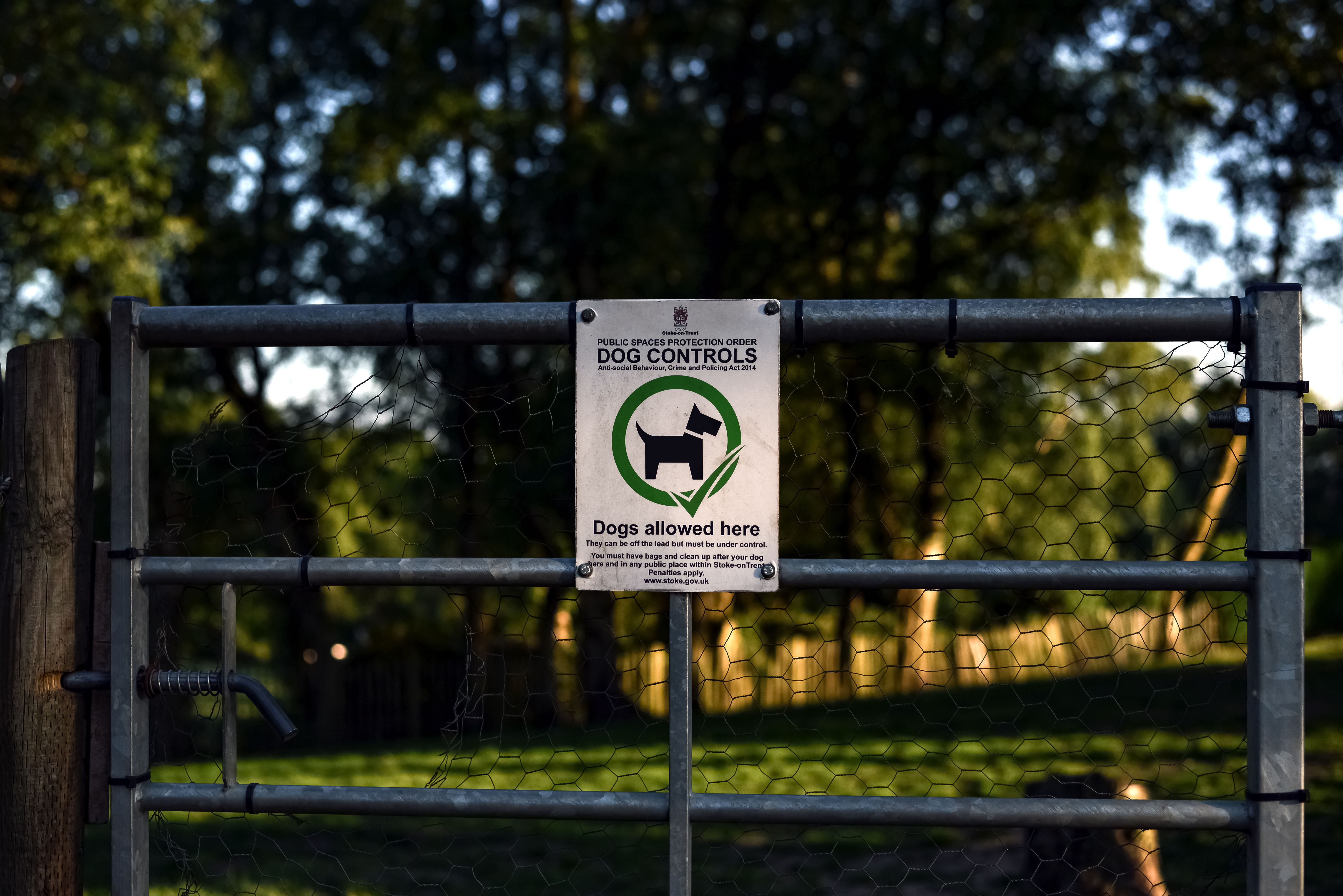Portail d'un parc avec un panneau de règlement pour les chiens
